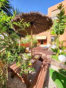 eine Terrasse mit einem Holztisch und einem Sonnenschirm in der Unterkunft MEDANO4YOU La Terraza De Isa in La Tejita