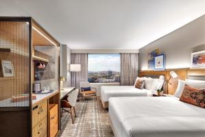 a hotel room with two beds and a desk at Omni Tempe Hotel at ASU in Tempe