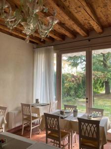 una sala da pranzo con tavoli, sedie e una grande finestra di Agriturismo San Michele a Vicenza