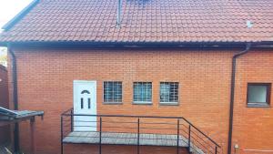 a brick building with a staircase leading to a white door at Apartman Stan na dan in Banja Koviljača
