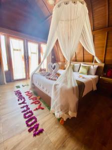 a bedroom with a bed with a bunch of wine bottles on the floor at Daphila Cottage in Nusa Penida