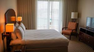 um quarto de hotel com uma cama e uma televisão em Costa Bahia Hotel Paseo Caribe em San Juan