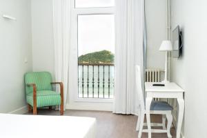 a room with a desk and a chair and a window at Hotel Niza in Donostia-San Sebastián