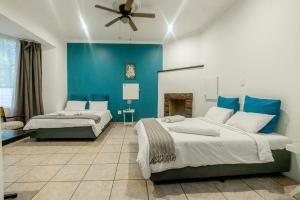 a bedroom with two beds and a blue wall at 54 Brecher in Pretoria