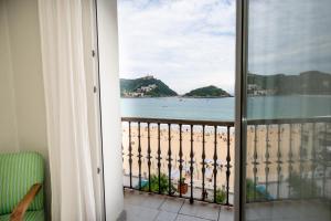 a room with a view of the beach from a balcony at Hotel Niza in Donostia-San Sebastián