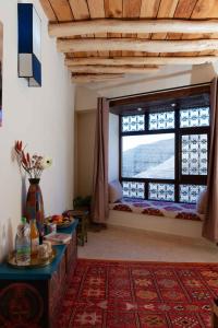 a living room with a large window and a table at Touda Ecolodge Atlas Mountains in Zawyat Oulmzi