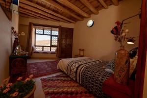 1 dormitorio con cama y ventana en Touda Ecolodge Atlas Mountains, en Zawyat Oulmzi