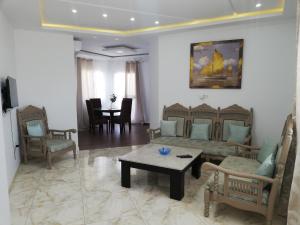 a living room with a couch and chairs and a table at Residence Debbabi in Monastir