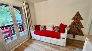 a bedroom with a red bed and a christmas tree at la foux d'allos au pied des pistes in La Foux