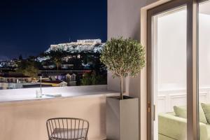een stoel en een potplant op een balkon bij Altar Suites in Athene