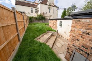 einen Hof mit grünem Gras neben einem Zaun in der Unterkunft Lovely Studio in Selly Oak 10 mins from city! in Birmingham