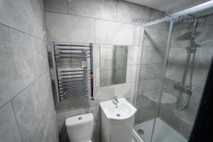 uma casa de banho com um chuveiro, um WC e um lavatório. em Lovely Studio in Selly Oak 10 mins from city! em Birmingham
