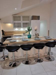 a kitchen with a large island with bar stools at Nalan Orrygeois, 6 pers, Astérix, CDG, CHANTILLY in Orry-la-Ville