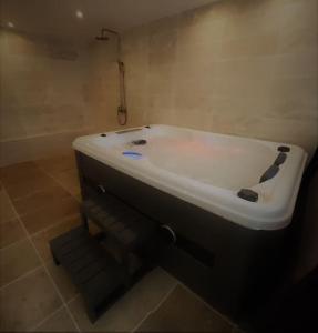 uma banheira branca sentada na casa de banho em Nalan Orrygeois, 6 pers, Astérix, CDG, CHANTILLY em Orry-la-Ville