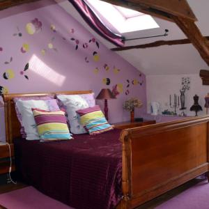 ein Schlafzimmer mit einem Bett mit Blumen an der Wand in der Unterkunft Le Logis de la Pataudière in Champigny-sur-Veude