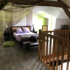 een slaapkamer met een bed met paarse kussens erop bij Le Logis de la Pataudière in Champigny-sur-Veude