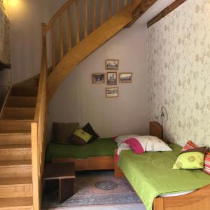 een slaapkamer met 2 bedden en een trap bij Le Logis de la Pataudière in Champigny-sur-Veude