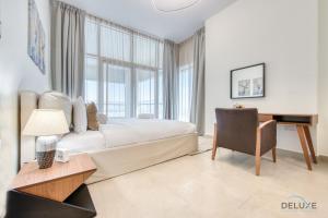 een slaapkamer met een bed, een bureau en een stoel bij Expansive 2BR at Azizi Aliyah Dubai Healthcare City by Deluxe Holiday Homes in Dubai
