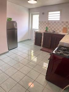 a kitchen with a refrigerator and a tile floor at Le petit cactus 2 in Bras-Panon +6 photos