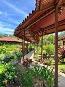 a garden with a pavilion with flowers and plants at La Foresta Nature Resort in Quepos