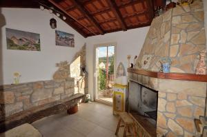 a living room with a stone fireplace and a window at House Tihana in Donje Selo na Šolti
