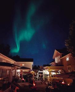 aurore dans le ciel au-dessus d'une ville la nuit dans l'établissement Pensionatet, à Piteå