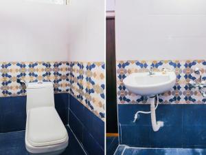 a bathroom with a white toilet and a sink at HZ INN in Hyderabad
