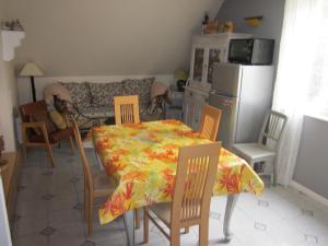 uma sala de jantar com mesa e cadeiras e uma cozinha em Mittenbach em Oberhaslach