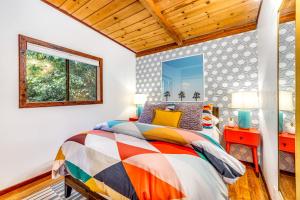 a bedroom with a colorful bed and a window at Tree Tops Bungalow in Guerneville
