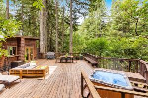 a deck with a jacuzzi tub in the woods at Tree Tops Bungalow in Guerneville