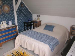 a bedroom with a bed with a blue comforter at Mittenbach in Oberhaslach