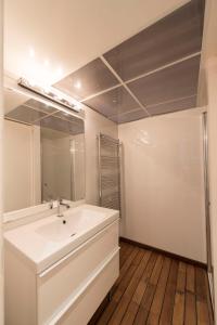 La salle de bains est pourvue d'un lavabo blanc et d'un miroir. dans l'établissement Couleur St Martin, à Paris