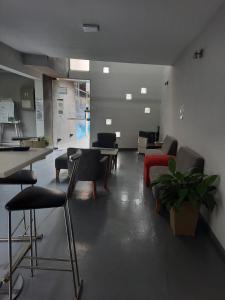 uma sala de estar com cadeiras, uma mesa e um sofá em Cañas Suites Urbanas em Mina Clavero