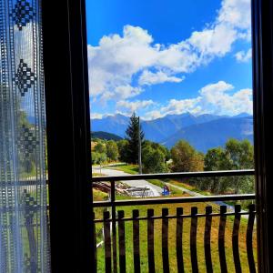 a window with a view of the mountains at Appartamento Monte Muggio - Your Mountain Holiday in Casargo