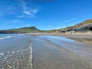 a beach with a mountain in the background at Craig-Y-Mor Bed & Breakfast with sea views Whitesands St Davids in St. Davids