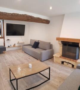 a living room with a couch and a tv at Nalan Johannisien, Maison piscine chauffée-Spa, Paris CDG-Disney in Jagny-sous-Bois