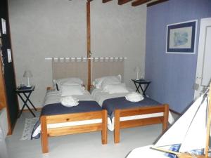 a bedroom with two twin beds and two tables at La Belle des Champs in Saint-Andelain