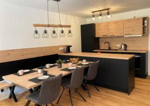 a kitchen with a wooden table and chairs in a kitchen at Wiesenquell Apartment Feldberg in Feldberg