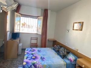 a bedroom with a bed with a blue comforter at Hotel Arce in San Pedro del Pinatar