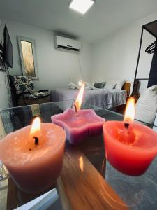 dos velas sentadas en una mesa en una sala de estar en Yogo Place in Nahariyya, en Nahariyya