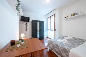 a bedroom with a bed and a wooden table at Homiday - Il Giardino --1 min Ospedale Cisanello--AEROPORTO FREE PARKING-- in Pisa
