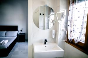 a bathroom with a sink and a mirror and a bed at B&B Best Hostel Milano in Milan