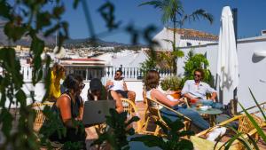 a group of people sitting on a patio at Veranera Hostel in Estepona