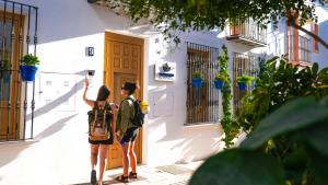 two people taking a picture of a building at Veranera Hostel in Estepona