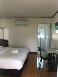 1 dormitorio con 1 cama, 1 mesa y 1 silla en บ้านวิรา ห้องพัก Baan Wira, en Khon Kaen