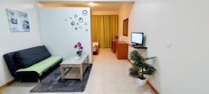 un salon avec un canapé, une table et une télévision dans l'établissement Apartamento Villa, à Ponta do Sol