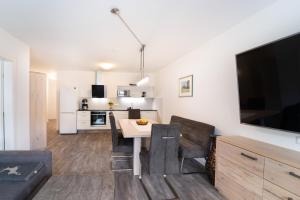 Il comprend une cuisine et un salon avec une table et une télévision. dans l'établissement Apartment Ski&Nature "Grosseck", à Mauterndorf