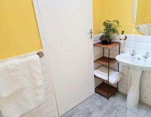 a bathroom with a sink and a toilet and a shower at Sunlight Cottage in Cape Town