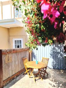 a wooden table and two chairs in front of a fence at Sunlight Cottage in Cape Town