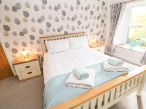sypialnia z łóżkiem z ręcznikami w obiekcie Glenridding Cottage w mieście Warcop